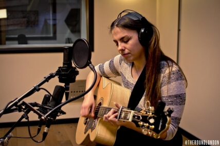 Woman recording acoustic guitar